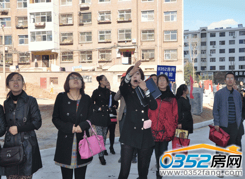 理想城置業(yè)顧問向顧客介紹小區(qū)景觀